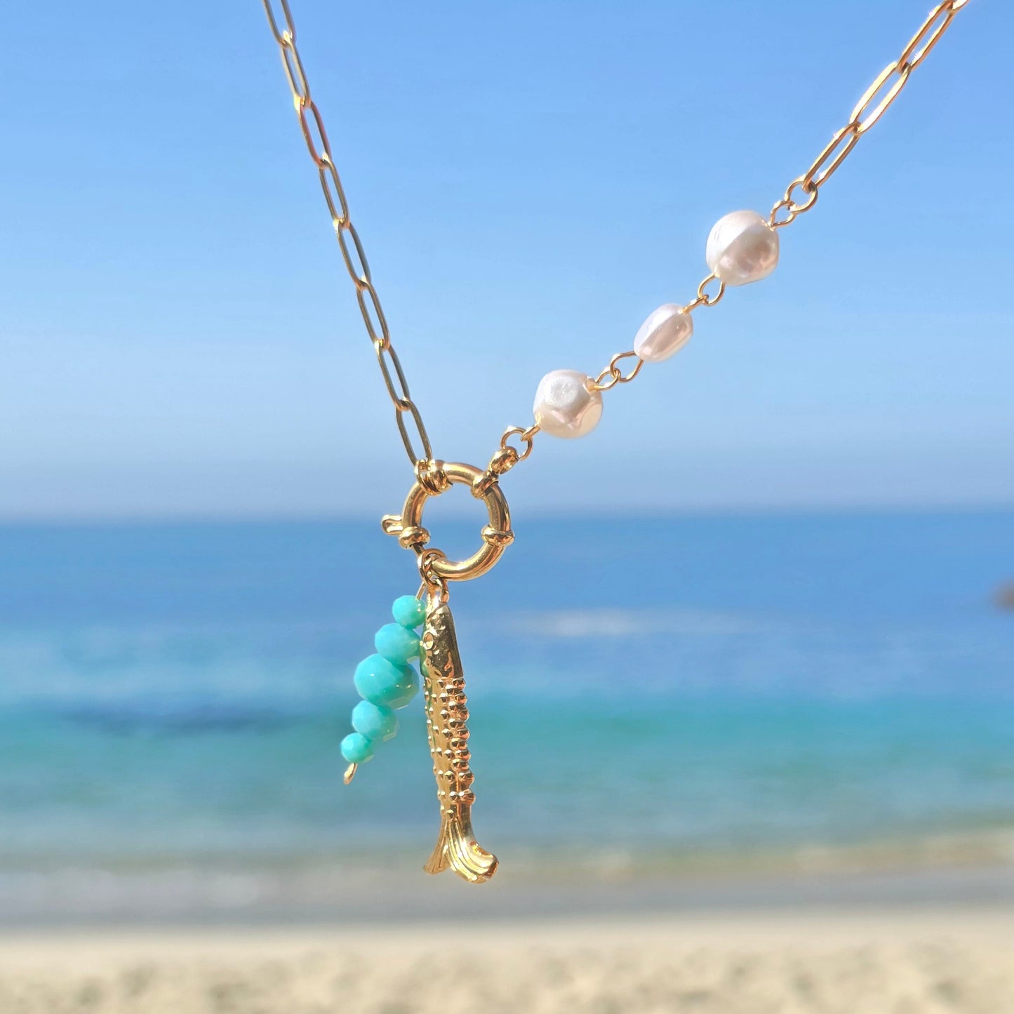 fish with emerald beads and pearl necklace gold